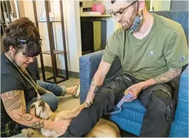  ?? ?? Donna Norton meets with Ian Dereus and his dog, Lola, at the hotel in Centennial, Colorado, where Norton helps people recovering from mental health and substance use disorders. Dereus is now considered a graduate and is living in his own apartment.