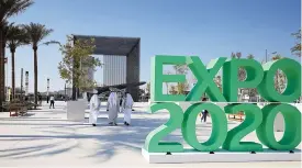  ?? (AFP) ?? People walk past the sign marking the Dubai Expo 2020 near the Sustainabi­lity Pavilion in Dubai on January 16