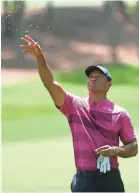  ?? STREETER LECKA/GETTY IMAGES ?? Tiger Woods checks the wind before hitting a shot Thursday. He is six shots back after shooting even-par 71.