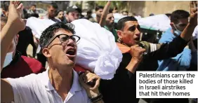  ??  ?? Palestinia­ns carry the bodies of those killed in Israeli airstrikes that hit their homes