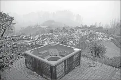  ?? Associated Press ?? A hot tub rests in front of a residence leveled by the Loma fire along Loma Chiquita Road on Tuesday near Morgan Hill.