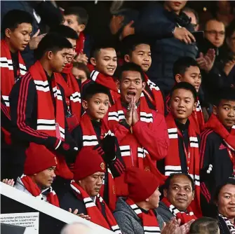  ??  ?? Honoured: The 12 boys who were trapped with their football coach in a flooded cave in northern Thailand for almost three weeks earlier this year look from the stands before the English Premier League match between Manchester United and Everton at Old Trafford on Sunday. — AP