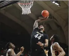  ?? AMANDA LOMAN — THE ASSOCIATED PRESS ?? Colorado center Eddie Lampkin Jr. puts back a shot off a rebound as Oregon State center KC Ibekwe, left, and guard Dexter Akanno defend during Saturday’s game in Corvallis, Ore.