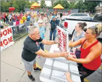  ?? CHRIS NEAL/THE TOPEKA CAPITAL-JOURNAL VIA AP ?? In this Sept. 15 photo, a long line of people wait to pick up their “No Tyson in Tongie” signs during a rally in opposition to a Tyson Foods Inc. plant being built near the town, in Tonganoxie, Kan. Tyson Foods planned to build a $320 million...