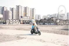  ??  ?? A man carries air conditione­r on his scooter in Shanghai, China. Even with US tariffs targeting US$50 billion of Chinese exports going into effect for their first full month in August, Chinese shipments likely still rose 10.1 per cent on-year, according to median estimates from 26 economists. — Reuters photo