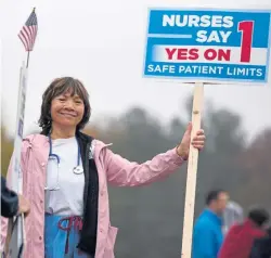  ?? ANGELA ROWLINGS / BOSTON HERALD ?? A WIN FOR NO: Nurse Casandra McIntyre, top, holds a sign yesterday as Kathy Leslie, above, a staff nurse, campaigns for Question 1.