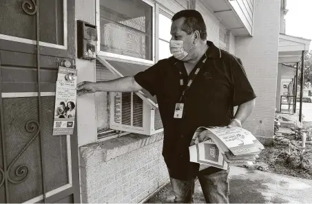  ?? Marvin Pfeiffer / Staff photograph­er ?? Manny Garcia, a recruit assistant with the U.S. Census Bureau, hangs a flyer encouragin­g residents to fill out their 2020 census forms on a door on Aug. 1 in the Cassiano Homes Apartments on San Antonio’s West Side.