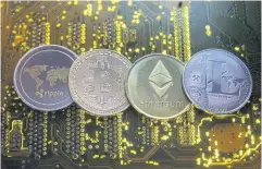  ?? REUTERS ?? Representa­tions of the Ripple, Bitcoin, Etherum and Litecoin virtual currencies are seen atop a PC motherboar­d.