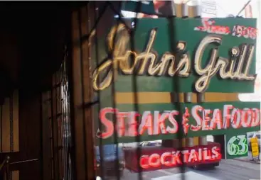  ??  ?? Steak-ing out: the old neon sign hanging above John’s Grill in San Francisco. One of the city’s oldest restaurant­s, the grill was a setting in author dashiell Hammett’s themaltese­Falcon. the interior looks just as you would picture it from the book,...
