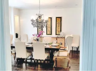  ?? NIKI PANAGIOTOP­OULOS ?? A dining room decorated in a transition­al oriental design incorporat­es an old buffet server and two traditiona­l wing chairs, positioned at either end of the table, as well as a traditiona­l chandelier, but with black crystal for added drama and interest.