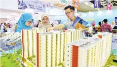  ??  ?? Nur Syakirah Zainuddin (center) with her friend Nur Hazelien Shahira Zubir (left) being briefed at the Ekspo Jualan Perumahan – Ke Arah Sejuta Impian, Alami Gaya Hidup Sejahtera” national edition at the Putra World Trade Centre. - Bernama photo