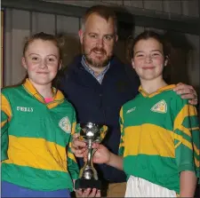  ??  ?? Joint captains Clarisse Ní Chonchubha­ir and Sorcha Ní Mhurchú receiving the trophy from Johnny Murphy (Rackard League Secretary).