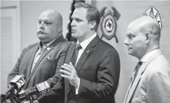  ?? Michael Ciaglo / Houston Chronicle ?? Houston Profession­al Fire Fighters Associatio­n president Marty Lancton, center, speaks Tuesday after a judge ruled the city improperly electionee­red against a ballot measure on firefighte­rs pay.