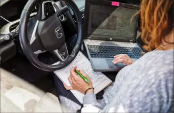  ?? Calla Kessler/New York Times ?? Gina Leonardo works online in her car April 29 while parked at Do Space, a community center in Omaha, Neb.