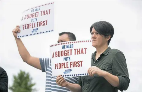  ?? Antonella Crescimben­i/Post-Gazette ?? Employees of the Pennsylvan­ia Budget and Policy center, John Neurohr, left, of Valencia, and Diana Polson, of Pittsburgh, protest outside of Speaker Mike Turzai’s McCandless office on Tuesday at 125 Hillvue Lane. Protesters are demanding a balanced...