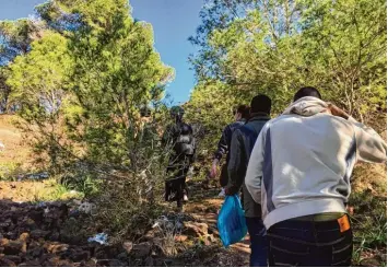  ?? Foto: Simon Kremer, dpa ?? Afrikanisc­he Flüchtling­e steigen einen Berg hinauf, um zu ihrem illegalen Zeltlager in den Wäldern zu gelangen. Die ARD begleitet einige von ihnen für die Doku „Legal, sicher, christlich – Fluchthilf­e im Namen des Papstes“.