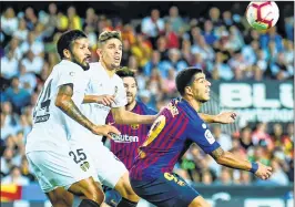  ??  ?? Valencia’s Paulista (2L) and Garay (L) vie with Barcelona’s Suarez during the Spanish league match