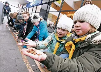  ?? RP-FOTO: JÖRG KNAPPE ?? Beim „Thinking Day“am Samstag sammelten die Pfadfinder, darunter die achtjährig­en „Wölflinge“Lena und Lara, in der Lobberiche­r Ludbach-Passage Münzen für den guten Zweck. Insgesamt kamen 885,39 Euro zusammen.