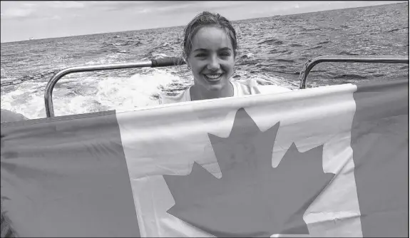  ?? CP Photo ?? Emily Epp is seen in an undated handout photo holding Canadian flag on board a boat on the English Channel. Epp, a 17- year- old from Kelowna, B. C., who just swam the English Channel and raised more than $ 40,000 for the children’s hospice Canucks...