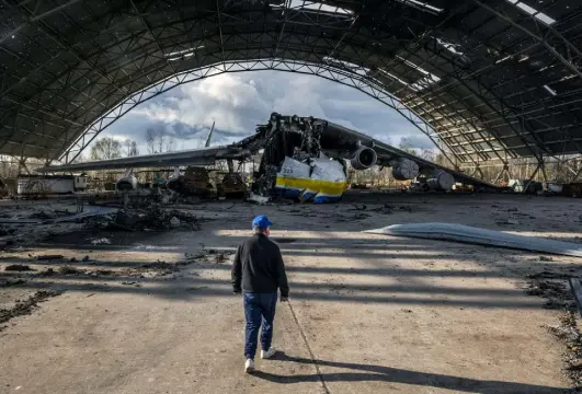  ?? Daniel Berehulak, © The New York Times Co. ?? Oleksandr Halunenko, the first pilot of Mriya, surveys damage to the world's largest cargo aircraft on Sunday at the Antonov airfield in Hostomel, near Kyiv, Ukraine.