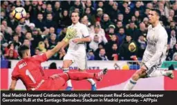  ??  ?? Real Madrid forward Cristiano Ronaldo (right) scores past Real Sociedadgo­alkeeper Geronimo Rulli at the Santiago Bernabeu Stadium in Madrid yesterday. – AFPpix