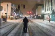  ?? ANDRE TEAGUE—ASSOCIATED PRESS ?? Dion Wiles takes advantage of the deserted streets to capture photos of the snow Bristol, Tennessee and Virginia state line early Sunday morning, Dec. 9, 2018. A storm spreading snow, sleet and freezing rain across a wide swath of the South has millions of people in its path, raising the threat of immobilizi­ng snowfalls, icy roads and possible power outages.