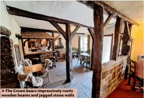  ?? ?? The Crown bears impressive­ly rustic wooden beams and jagged stone walls