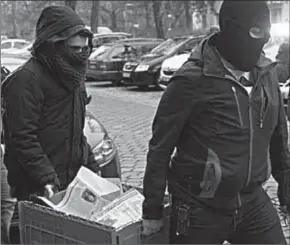  ??  ?? Police officers seize evidence in a raid on The True Religion Islamist organizati­on in Berlin. (Photo: EPA)