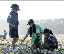  ?? Picture: MADELEINE CHAPUT ?? CLEANING UP: Rajeshree Govender, centre, and her two children, Uvesh, left, and Akiera, sift through the sand in search of nurdles and other plastic waste to fill up their eco-bricks, on Nahoon Beach