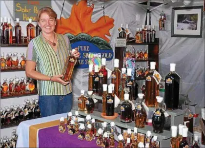  ??  ?? BOB BARRETT — PHOTO PROVIDED Pam McCutchen shows off Berkshire Sweet Gold Maple Farm’s solar produced Maple products at the Woodstock-New Paltz Arts and Craft Fair. The Charlemont, Massachuss­ets-based vendor will return for this year’s fair.