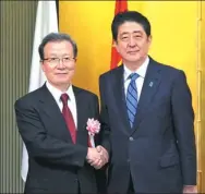  ?? TENG XUE / FOR CHINA DAILY ?? Chinese Ambassador to Japan Cheng Yonghua (left) shakes hands with Japanese Prime Minister Shinzo Abe in Tokyo on Thursday.