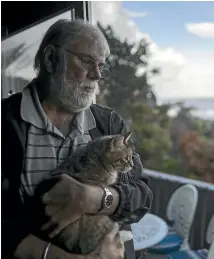  ??  ?? Rex Wishnowsky and his cat Pinkie back at their home in Hector, near Westport, after being during ex-Tropical Cyclone Gita.