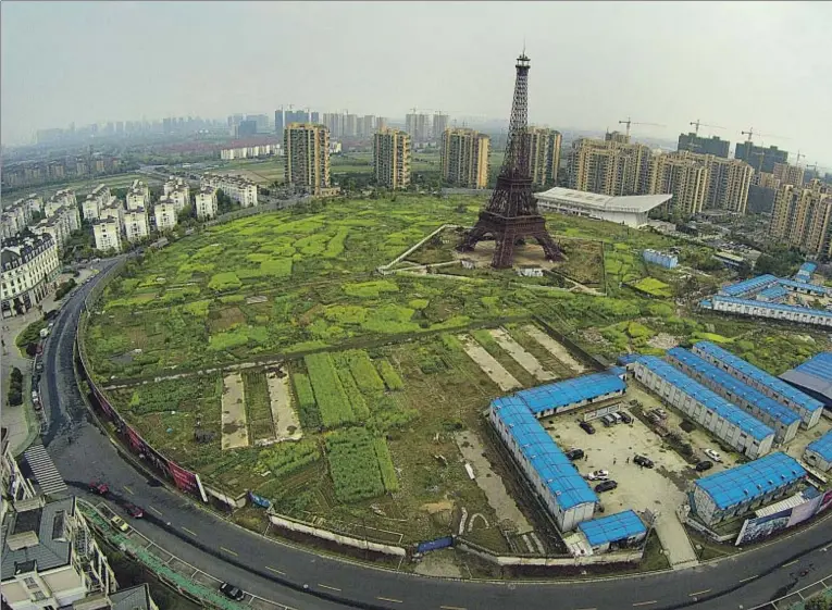  ??  ?? Una reproducci­ón de la torre Eiffel de 108 metros entre huertos en Hangzhou, provincia de Zhejiang