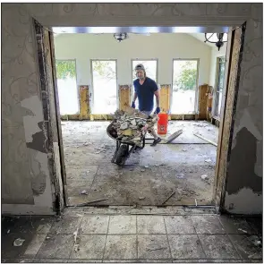  ?? Arkansas Democrat-Gazette/STATON BREIDENTHA­L ?? Ryan Bennett on Monday afternoon tears out Sheetrock from his grandmothe­r’s house on Willow Beach Road in North Little Rock after floodwater­s got inside last week.