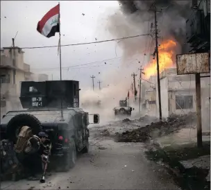  ??  ?? A car bomb explodes next to Iraqi special forces armoured vehicles as they advance towards Islamic State-held territory in Mosul, Iraq. PICTURE: AP