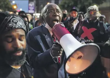  ?? John Minchillo Associated Press ?? THE REV. DR. Charles Elliott Jr. addresses protesters Thursday in Louisville, Ky. Authoritie­s pleaded for calm as activists vowed to f ight on after a gunman wounded two police off icers on Wednesday during protests.