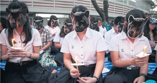  ?? PATIPAT JANTHONG ?? Chulalongk­orn University students wear black panther masks as they hold a symbolic vigil to mourn the killing of the protected animal by hunters allegedly including constructi­on tycoon Premchai Karnasuta, pictured above.