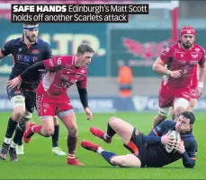  ??  ?? SAFE HANDS Edinburgh’s Matt Scott holds off another Scarlets attack