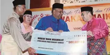  ??  ?? DR Tengku Muhammad Fa-iz (kanan) menerima replika cek berjumlah RM500,000 sumbangan wakaf daripada Bank Muamalat yang disampaika­n Mohd Redza.