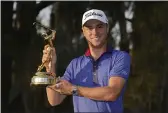  ?? JOHN RAOUX — THE ASSOCIATED PRESS ?? Justin Thomas holds the trophy after winning The Players Championsh­ip golf tournament on Sunday in Ponte Vedra Beach, Fla.