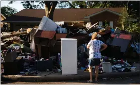  ?? MATT ROURKE / AP PHOTO ?? Tamlyn Lima views debris piled in front of her home Wednesday in the aftermath of Hurricane Harvey in Houston.