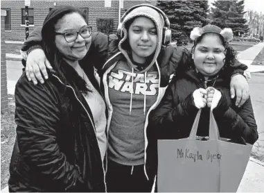  ?? CAROLYN THOMPSON/AP ?? Roxanne Ojeda-Valentin, left, with her children, Malachi and Makayla Ojeda, leave the kids’ school in Buffalo, New York, on March 17 with textbooks and assignment­s to work on while the district is closed due to the coronaviru­s.