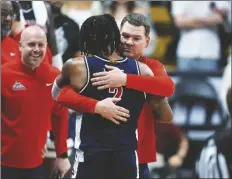  ?? DAVID ZALUBOWSKI/AP ?? ARIZONA COACH TOMMY LLOYD (RIGHT) hugs guard Caleb Love, who was pulled during the second half of the team’s game against Colorado on Feb. 10 in Boulder, Colo.