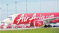  ?? KRIT PHROMSAKLA NA SAKOLNAKOR­N ?? An A320 aircraft of AirAsia is seen at Bangkok’s Don Mueang airport, the hub of the airline.