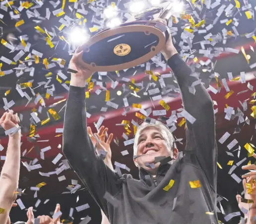  ?? GRACE HOLLARS/INDYSTAR ?? Coach Matt Painter holds up the NCAA men’s tournament Midwest Regional trophy after his Purdue squad beat Tennessee last Sunday in Detroit.