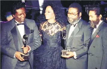  ?? RON FREHM AP FILE ?? Diana Ross joins songwriter­s (from left) Lamont Dozier, Brian Holland and Eddie Holland after the Motown writing team was inducted into the Rock & Roll Hall of Fame in New York on Jan. 17, 1990.