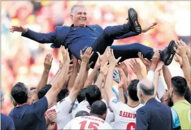  ?? ?? Carlos Queiroz, manteado por sus propios jugadores tras la victoria ante Gales.