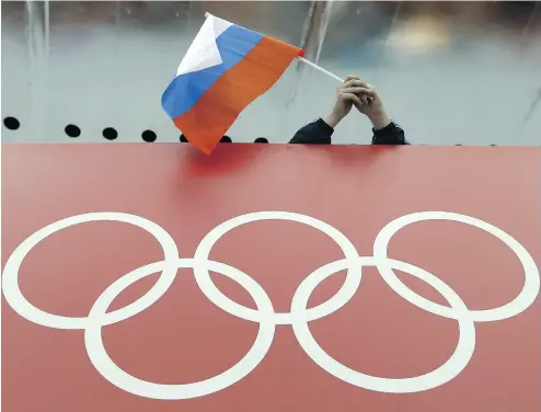  ?? DAVID J. PHILLIP / THE ASSOCIATED PRESS FILES ?? A skating fan holds Russia’s national flag before the start of a speedskati­ng race during the 2014 Winter Olympics. WADA is expected to announce this week that the Russia Anti-Doping Agency remains non- compliant.