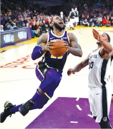  ?? ASSOCIATED PRESS ?? Los Angeles Lakers forward LeBron James, left, goes up for a shot as San Antonio Spurs forward Dante Cunningham defends during the second half of an NBA basketball game in Los Angeles. The Lakers won 121-113.