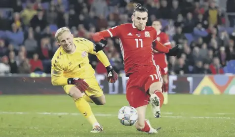  ??  ?? Gareth Bale skips past Kasper Schmeichel before prodding the ball into the keeper’s net. But it was too little too late for Wales.